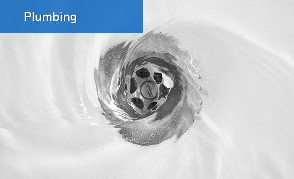 Water swirls around and down a clean drain.