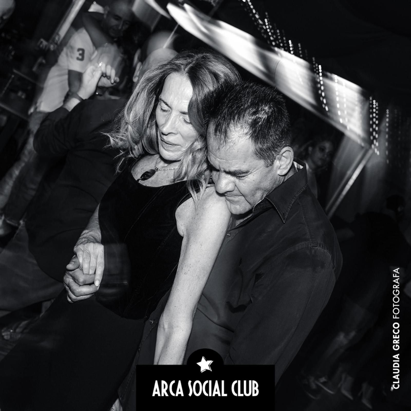 Tagliere di salumi su un tavolo con vista sulle montagne, sole splendente e cielo azzurro.