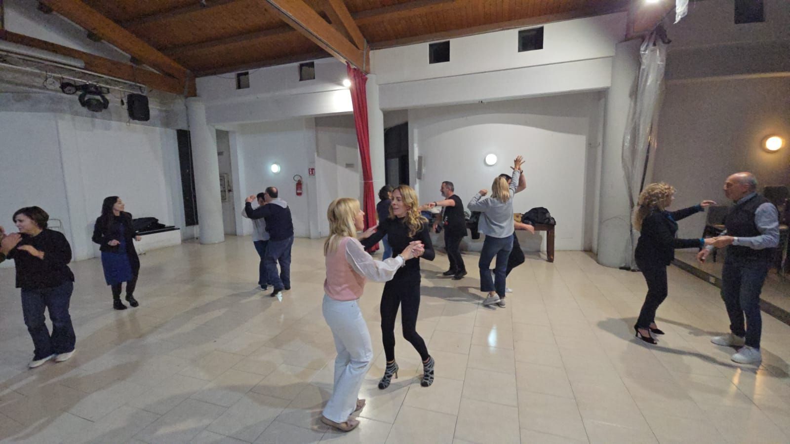 Tagliere di salumi su un tavolo con vista sulle montagne, sole splendente e cielo azzurro.
