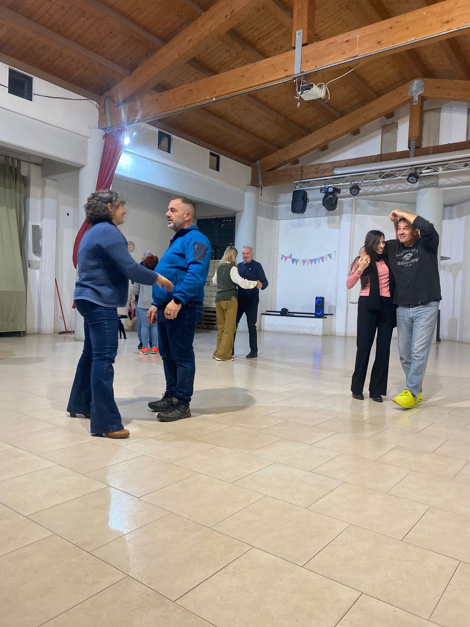 Piatto di pasta con tagliatelle scure, salsa cremosa ed erbe aromatiche, servito in una ciotola bianca.