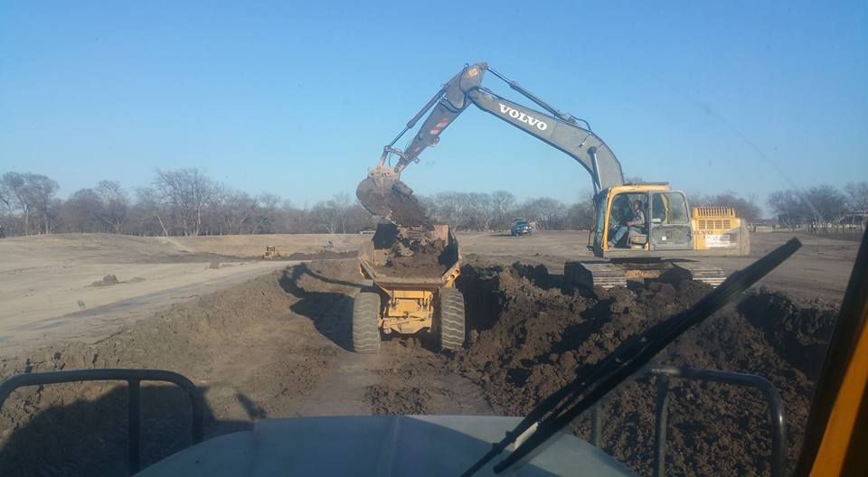 A person holding a baby up in the air indoors near a window, baby smiling.