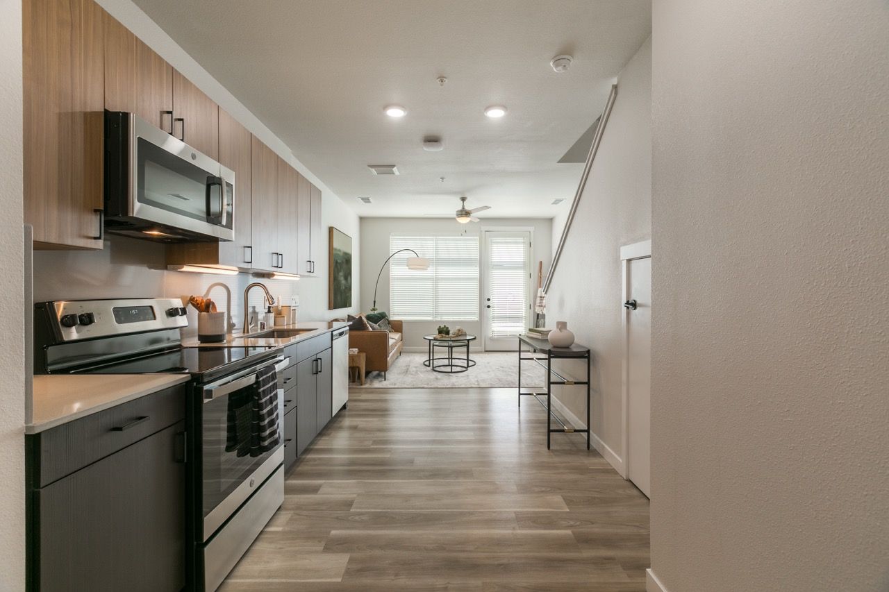 Open-concept kitchen with stainless-steel appliances and a living area with sofa and coffee table.