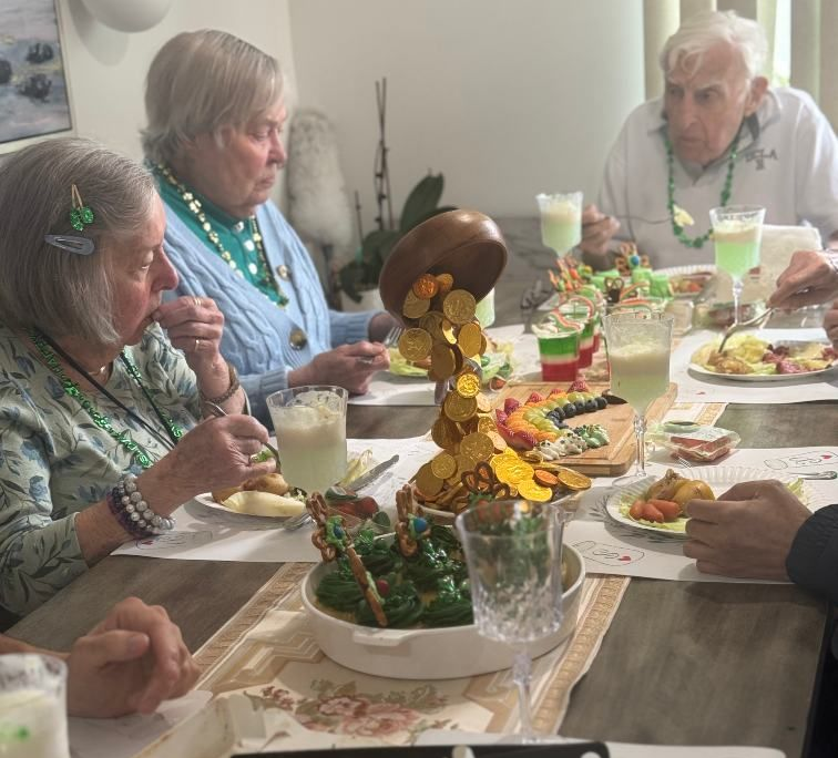 Elderly people at a table, enjoying tea and desserts. Interior shot, bright. Pepper Tree Assisted Living in Lomita, CA.
