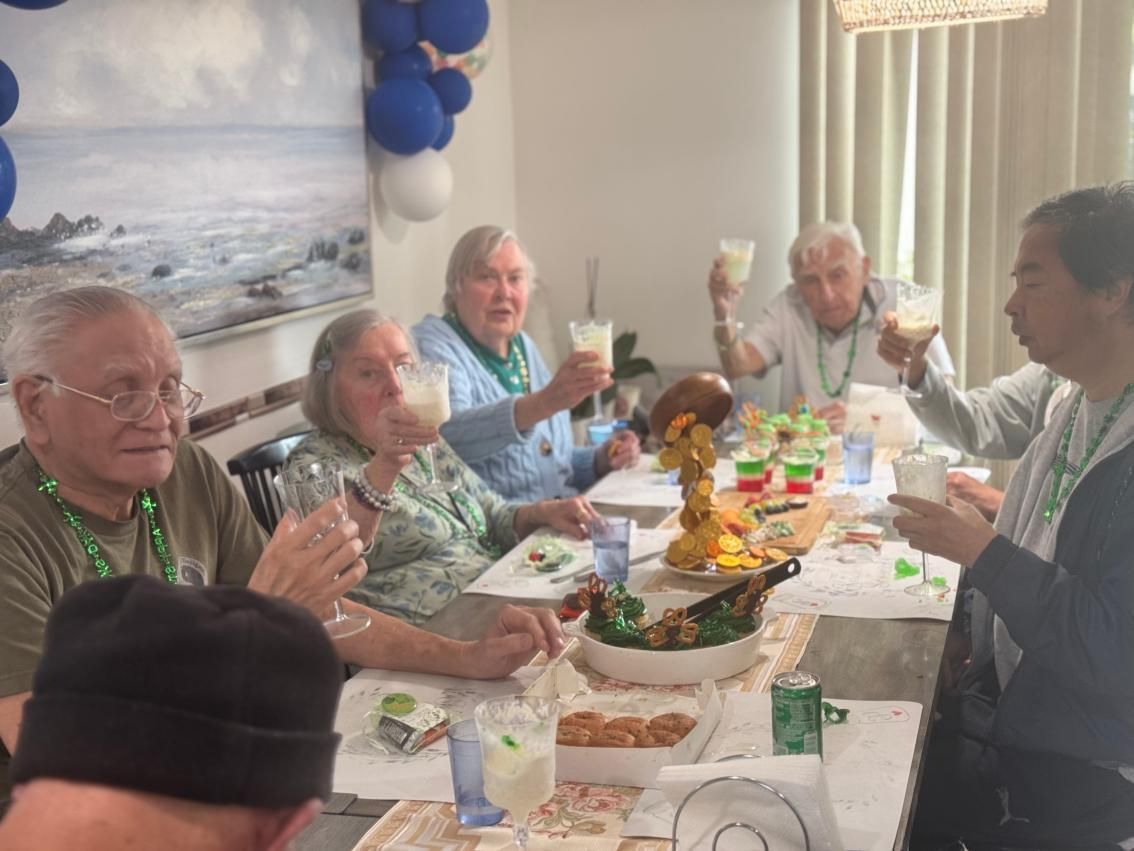 People eating together at round tables in a bright, casual dining room. Pepper Tree Assisted Living in Lomita, CA.