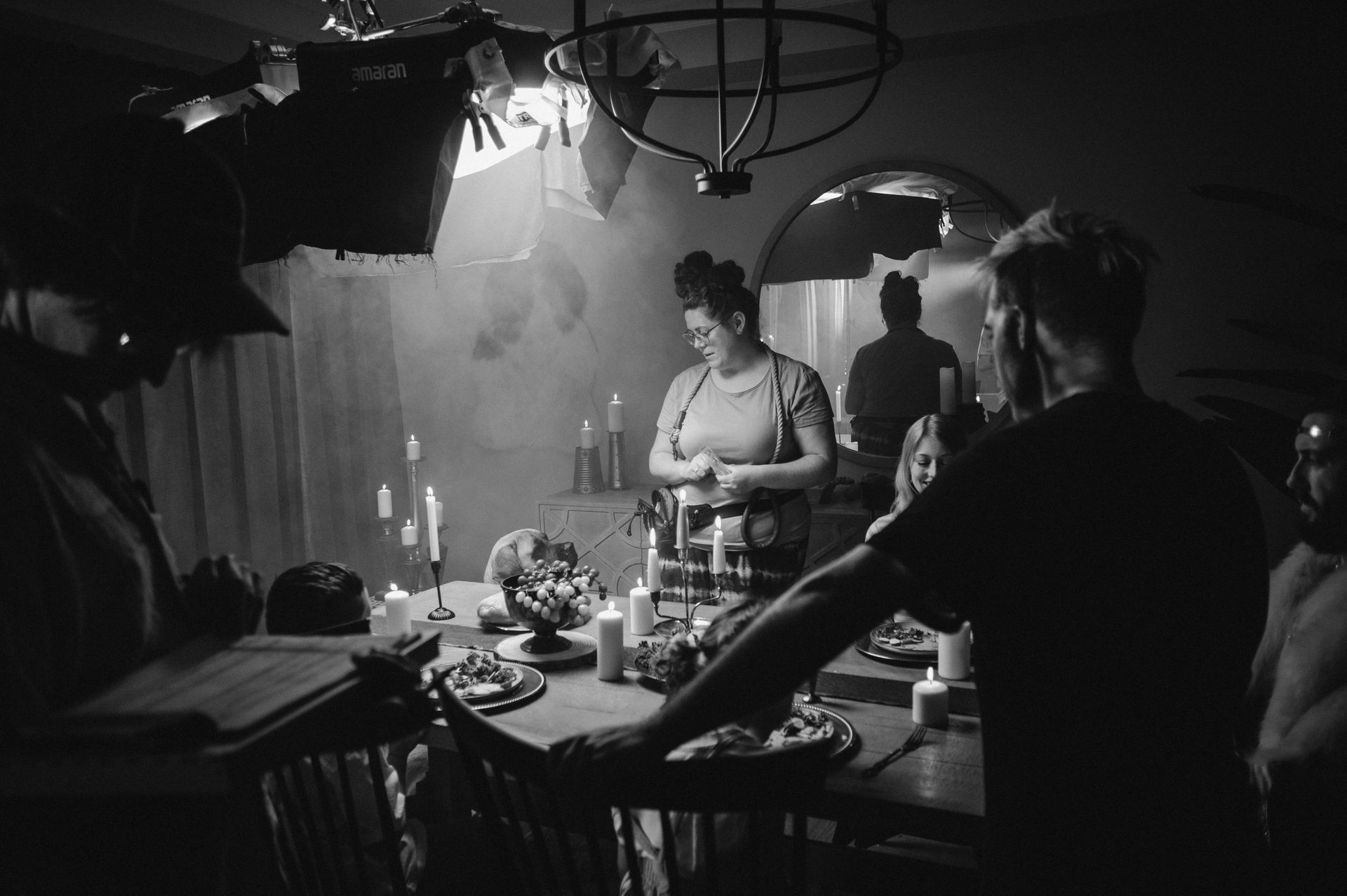 A black and white photo of a group of people standing around a table.