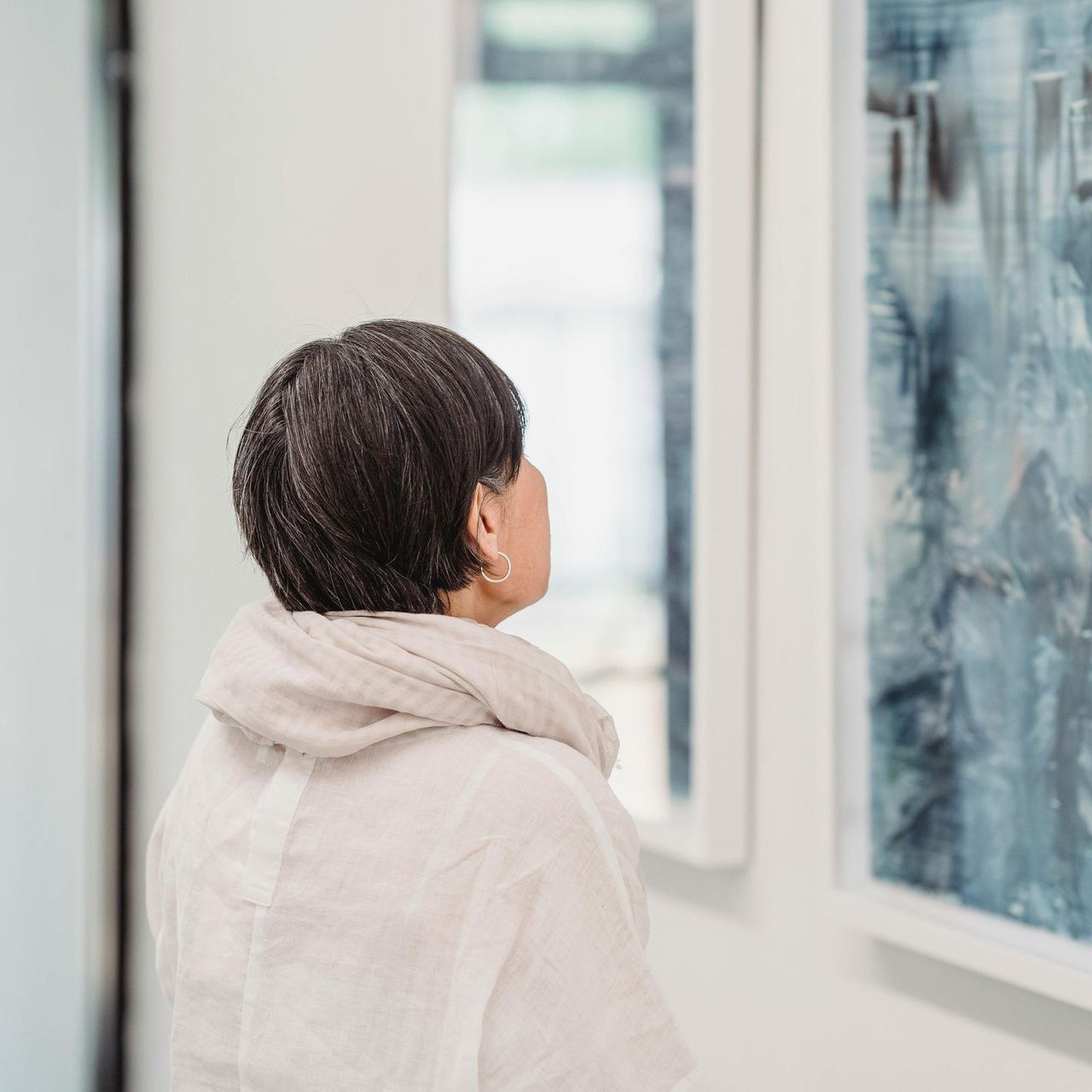A woman looking outside a window, representing a fresh look over business initiatives
