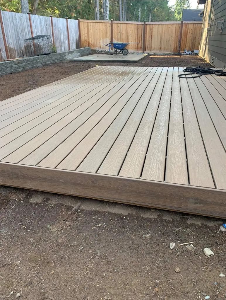 A wooden deck is being built in a backyard.
