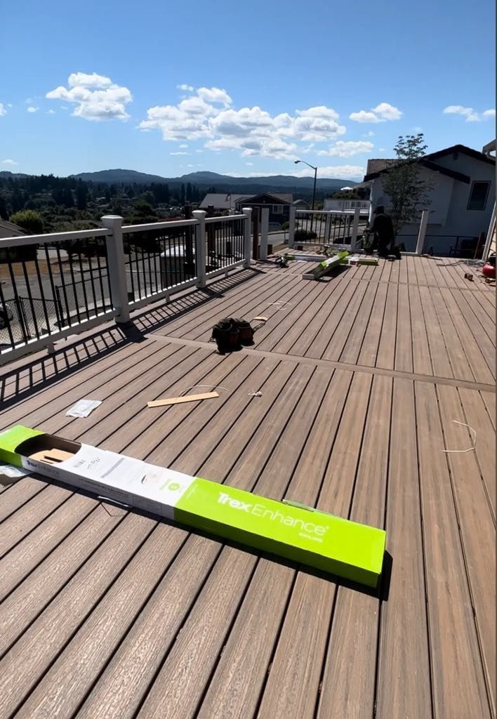 A dog is laying on a wooden deck next to a green box.