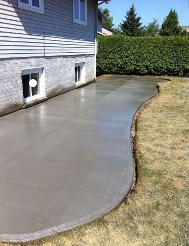 A concrete walkway is being built in front of a house.