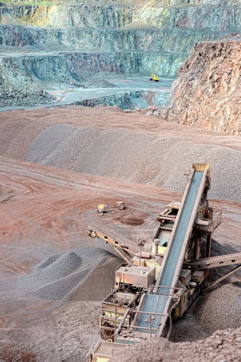 a conveyor belt is moving gravel in a quarry .