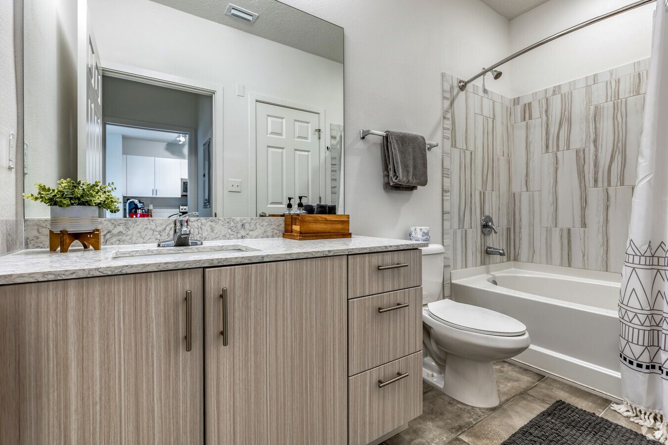 A bathroom with a sink , toilet , tub and mirror.