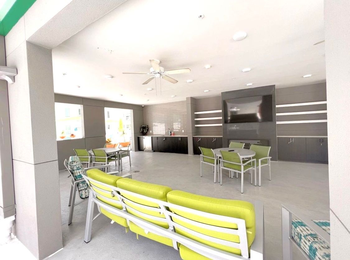 A large room with tables and chairs and a ceiling fan.