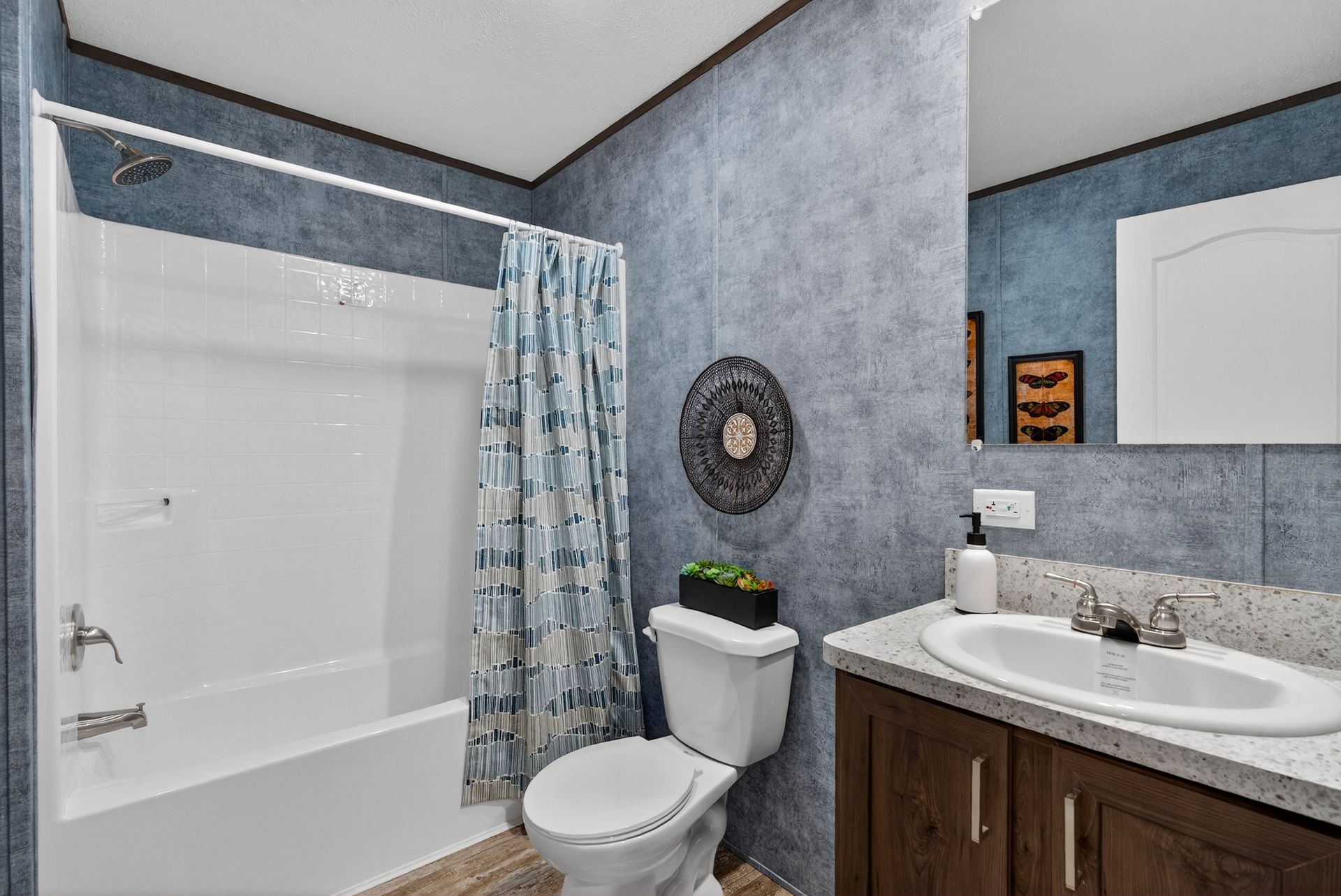 Modern bathroom with bathtub, toilet, sink vanity, and blue-gray walls
