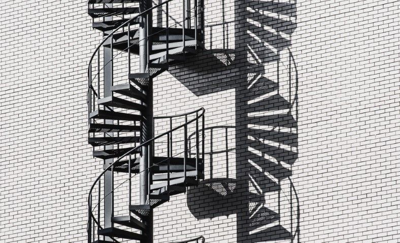 Spiral staircase with black metal railing in a modern Suffolk building.