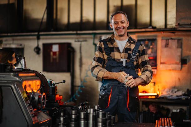 A man working near machinery and metal rods. A man working near machinery and metal rods.