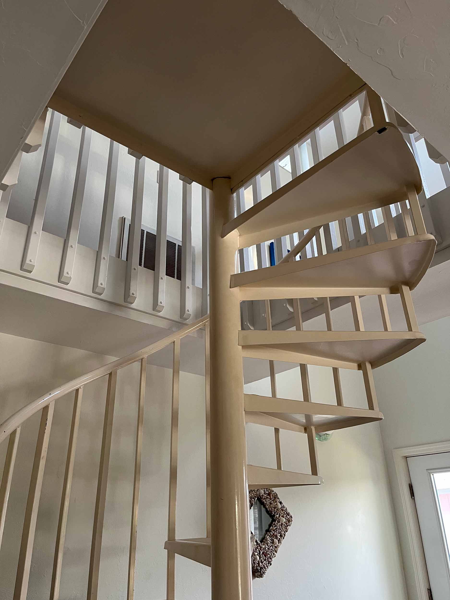 Spiral staircase with white metal railing in a modern Suffolk building.