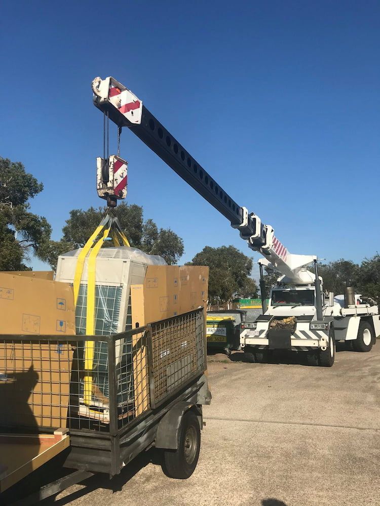 A Large Crane is Lifting a Large Box on a Trailer — Davies Refrigeration & Air Conditioning in Warana, QLD