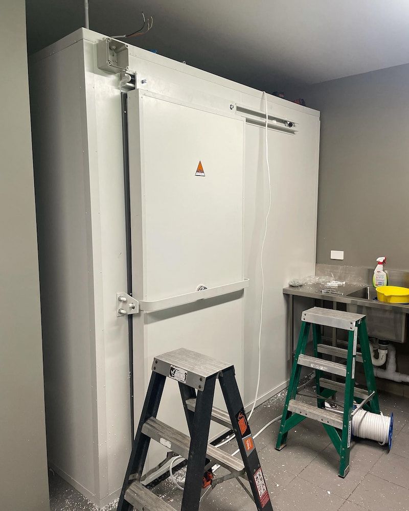 A Ladder is Sitting in Front of a Refrigerator in a Room — Davies Refrigeration & Air Conditioning in Warana, QLD