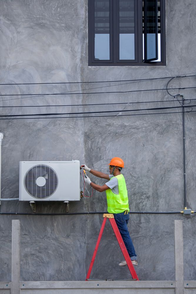 A Man is Standing on a Ladder Fixing an Air Conditioner — Davies Refrigeration & Air Conditioning in Warana, QLD