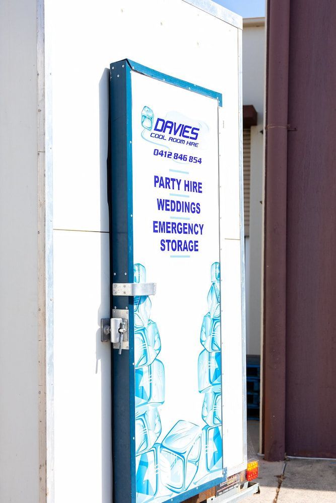 A White Building With a Blue and White Sign — Davies Refrigeration & Air Conditioning in Warana, QLD