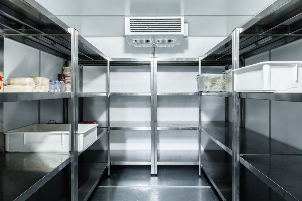 An Empty Refrigerator With Stainless Steel Shelves in a Kitchen — Davies Refrigeration & Air Conditioning in Warana, QLD
