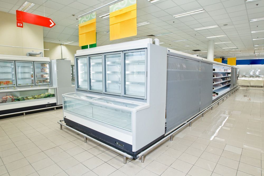 An Empty Grocery Store With a Lot of Shelves and Refrigerators — Davies Refrigeration & Air Conditioning in Warana, QLD