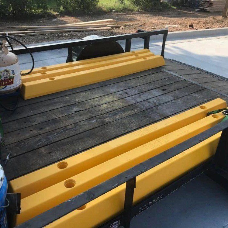 Yellow parking blocks on a wooden trailer bed. A propane tank sits on the side.
