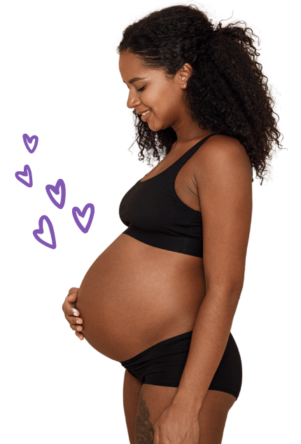 A pretty young pregnant woman looks adoringly at her baby bump with sketched hearts floating above