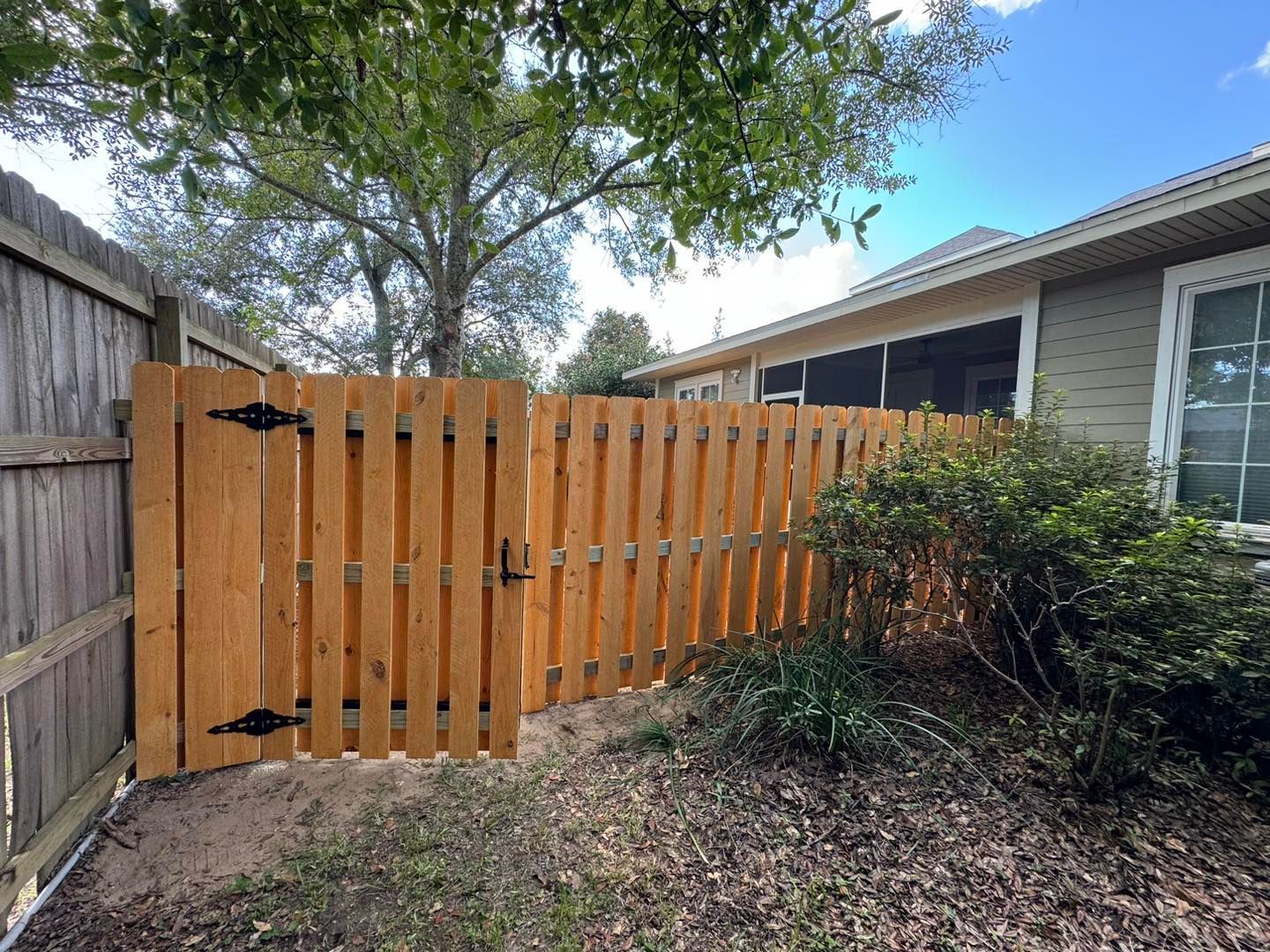 Wooden deck surrounding a blue swimming pool with a wooden railing in a backyard setting.