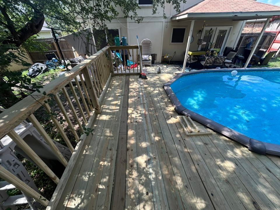 Wooden deck next to a blue swimming pool, attached to a house with a covered patio.