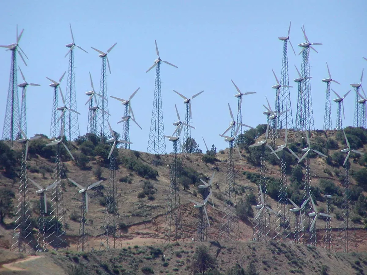 A bunch of wind turbines on top of a hill