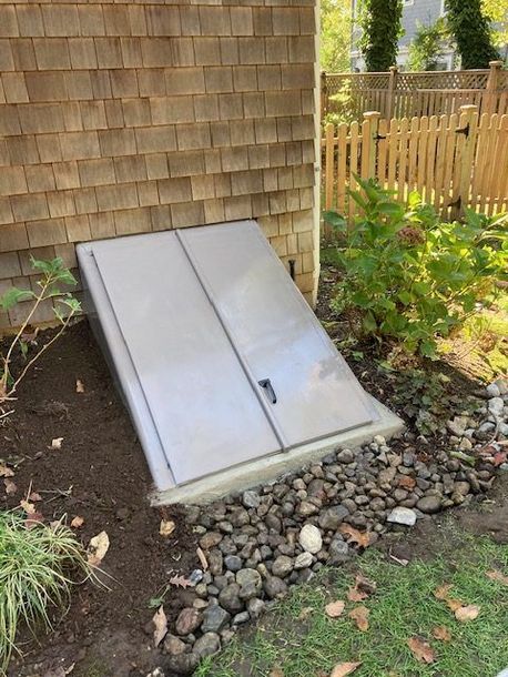 A stainless steel door is sitting on the side of a house.