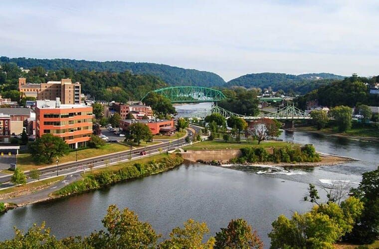 An aerial view of a river with a bridge in the background