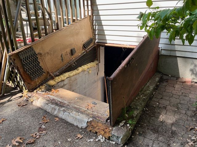 A wooden door is open in the basement of a house.