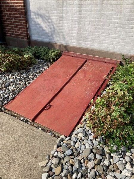 A red door with a brick wall in the background