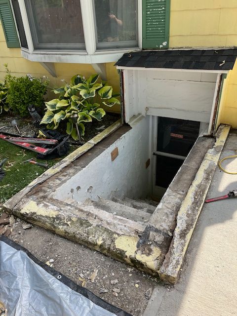 A basement window with stairs leading up to it