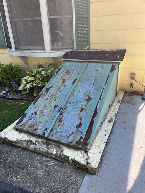 A blue door is sitting in front of a yellow house.