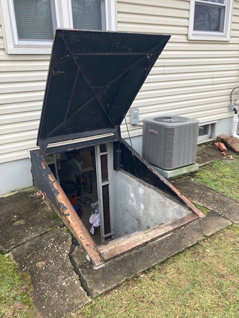 An air conditioner is sitting next to a basement door.