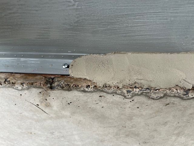 A close up of a concrete wall with a metal trim.