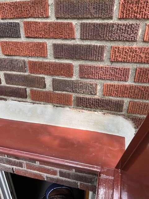 A close up of a brick wall with a window sill.