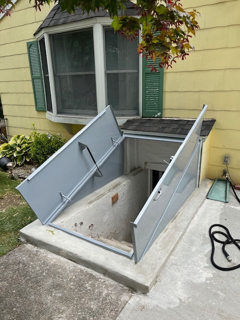 A yellow house with a window and a door that is open