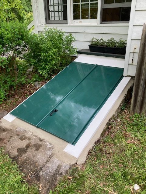 A green door is sitting in front of a house.