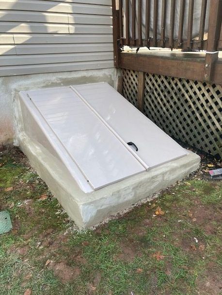 A white door is sitting in the grass next to a house.