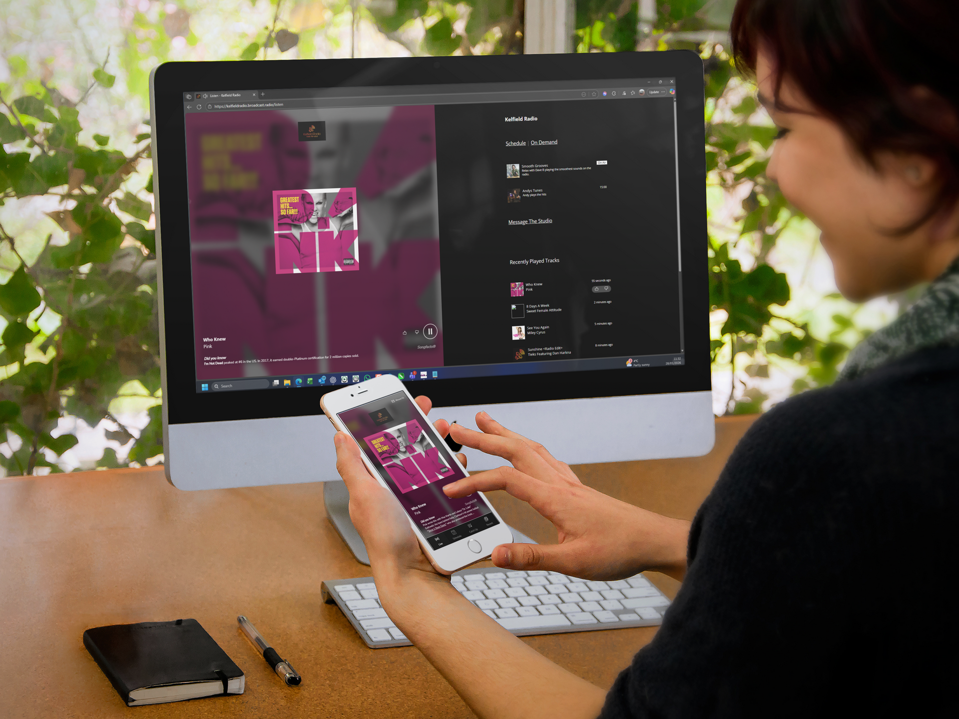 Lady listening to a radio station, via the Broadcast Radio Web Player, on her Mac and phone.