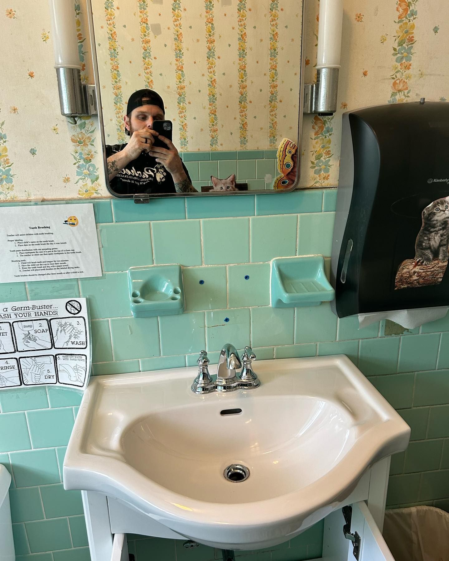 A man is taking a picture of himself in a bathroom sink.