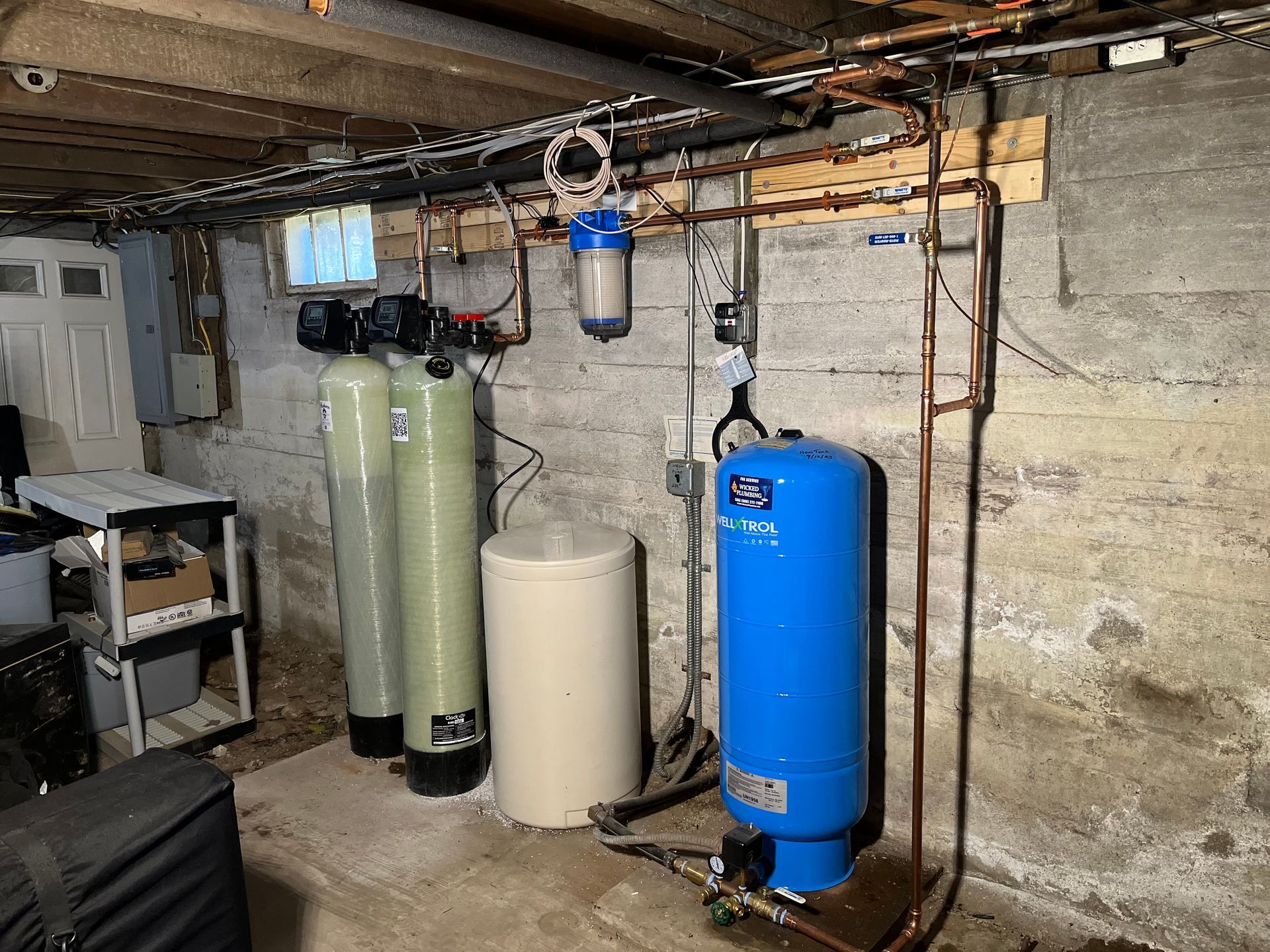 A basement with a lot of water tanks and pipes.