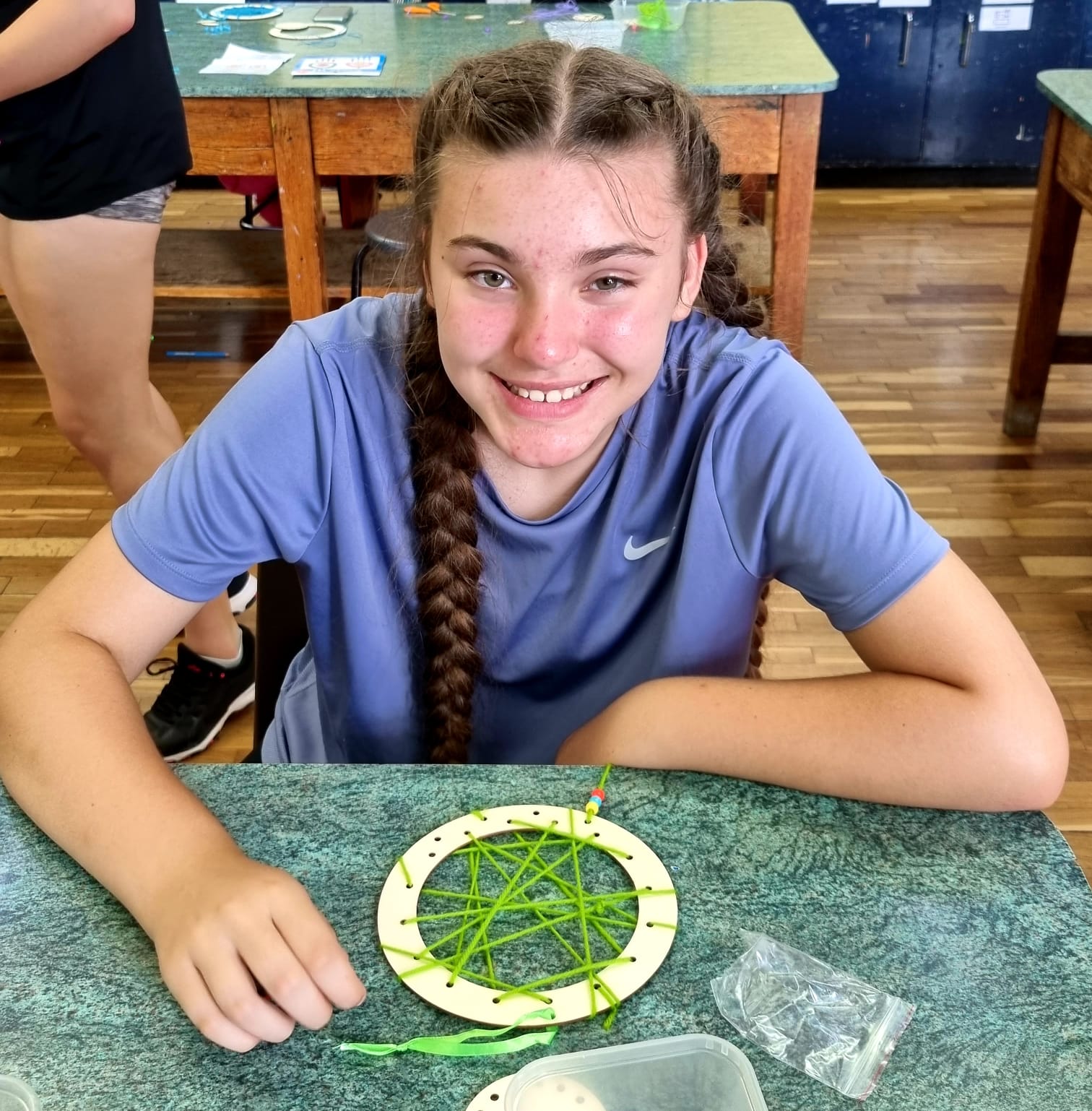 A girl in a blue nike shirt sits at a table