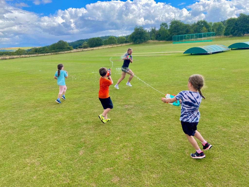 A group of children are playing with a kite in a field.