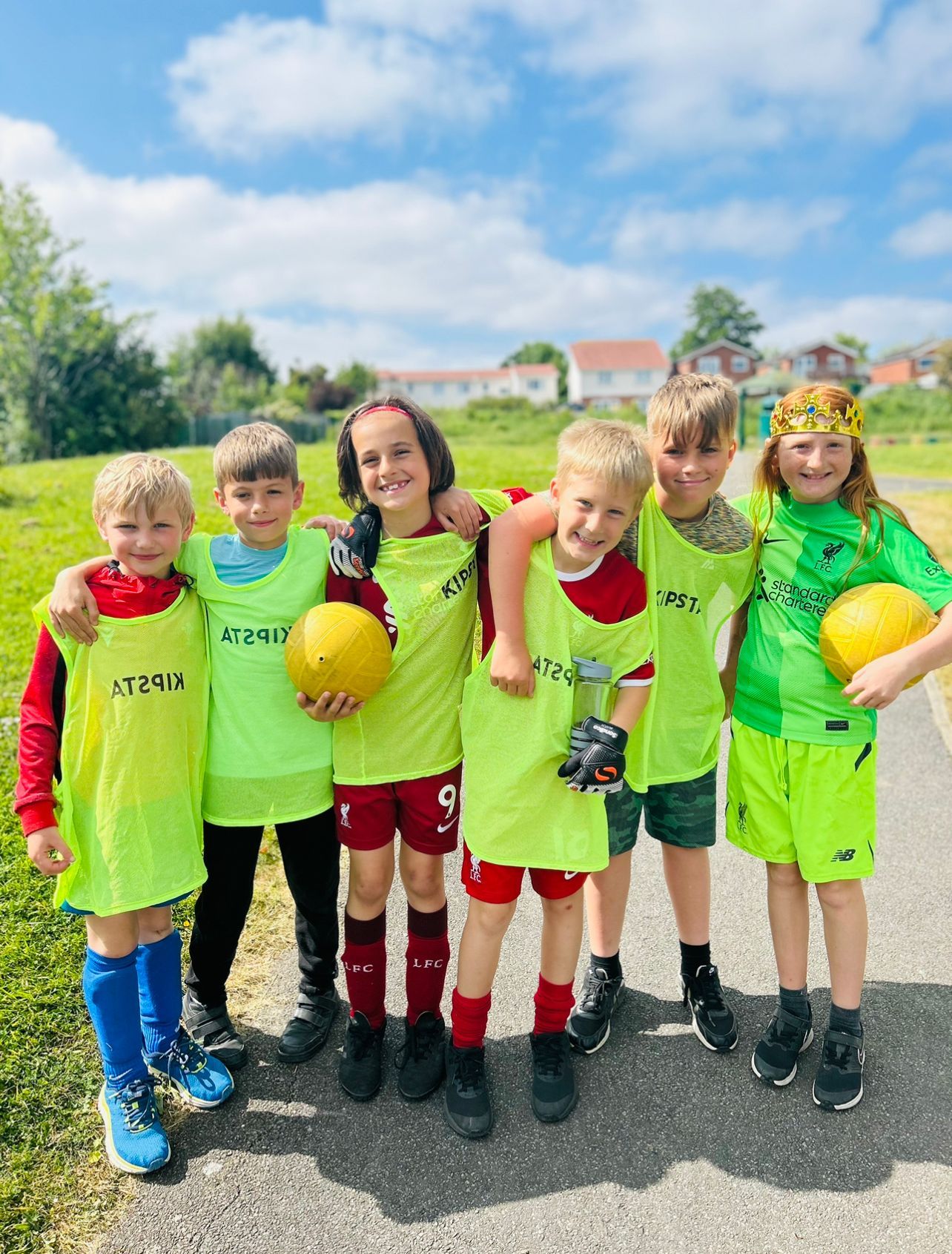 A group of young children are posing for a picture while holding soccer balls.