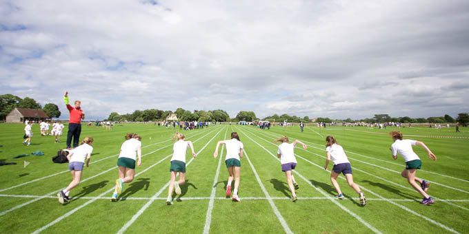 A group of people are running on a track.